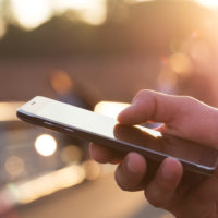 Man using his Mobile Phone outdoor, close up